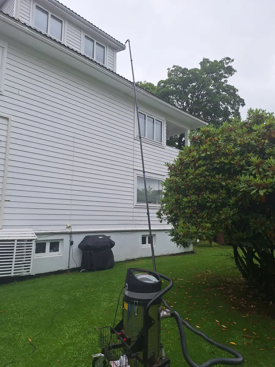 Takrennerens på hvitt hus med SkyVac-suger på plenen